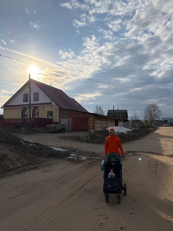 Parent pushes stroller through residential Chaikovsky neighborhood