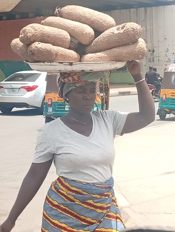 Woman carries root vegetables on head in Jos, Nigeria