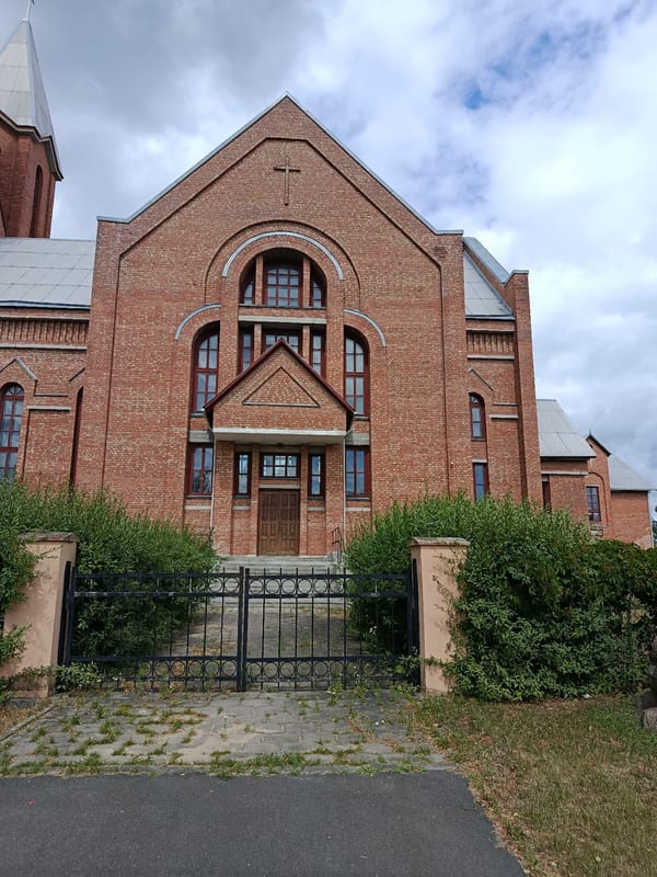 Svietlahorsk landmarks: church, river, and park on a grey summer day