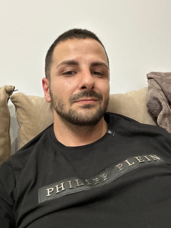Man in designer shirt relaxes on beige cushions indoors