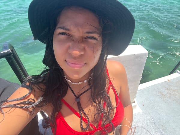 Woman in red swimsuit relaxes by turquoise water in Venezuela