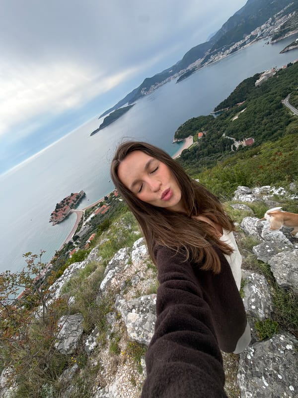 Woman takes selfie overlooking coastal Pržno, Montenegro