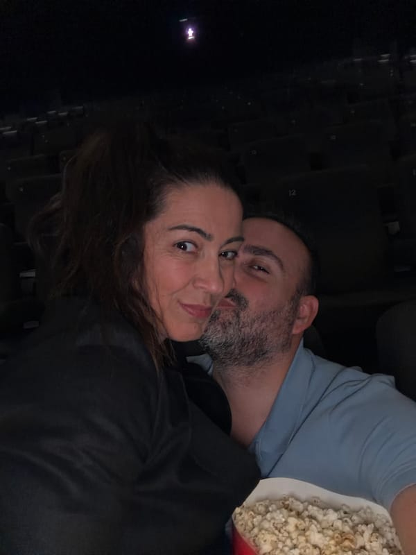 Couple shares movie theater popcorn during cinema visit