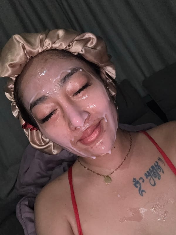 Person documented applying skincare treatment in dimly lit setting