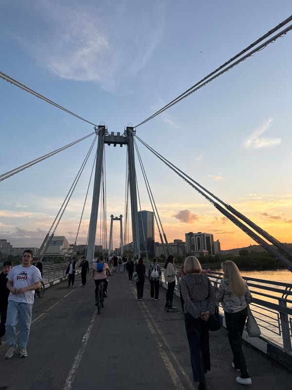 Rollerblader enjoys sunset near Krasnoyarsk bridge during golden hour