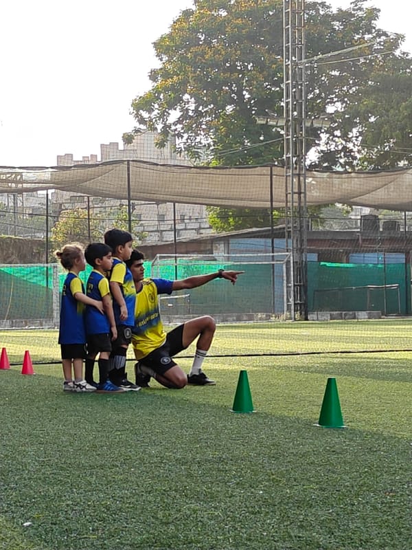 Youth soccer team practices drills on Mumbai field