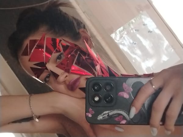 Woman takes mirror selfie with geometric face decorations