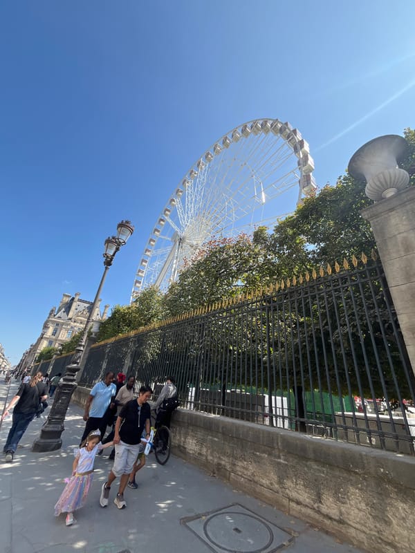 Ferris wheel and Louvre architecture on a sunny Paris afternoon