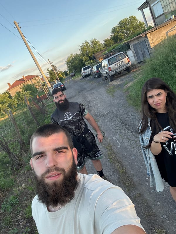 Three people gather on gravel road in Bulgarian village