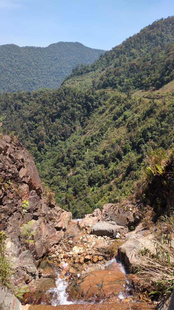 Rocky cliff with waterfall observed in Vietnamese mountains