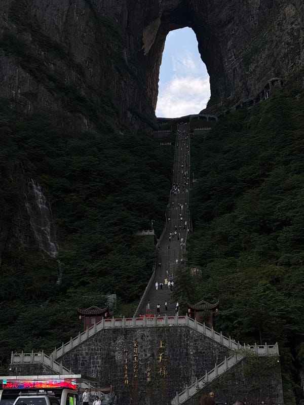 Steep staircase climbs through a giant natural cliff arch, Zhangjiajie