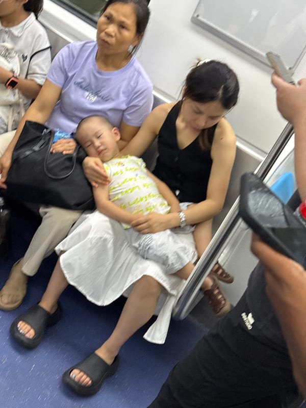 Child naps on a lap during a calm subway ride