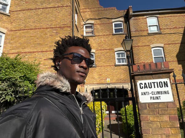 Man in fur-trimmed jacket photographed outside London brick building