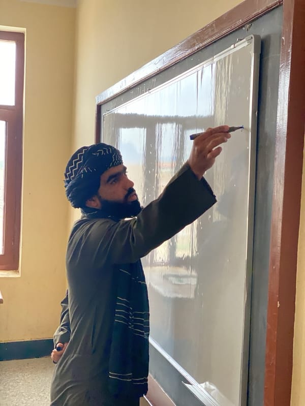 Man with marker beside whiteboard in Kandahar room