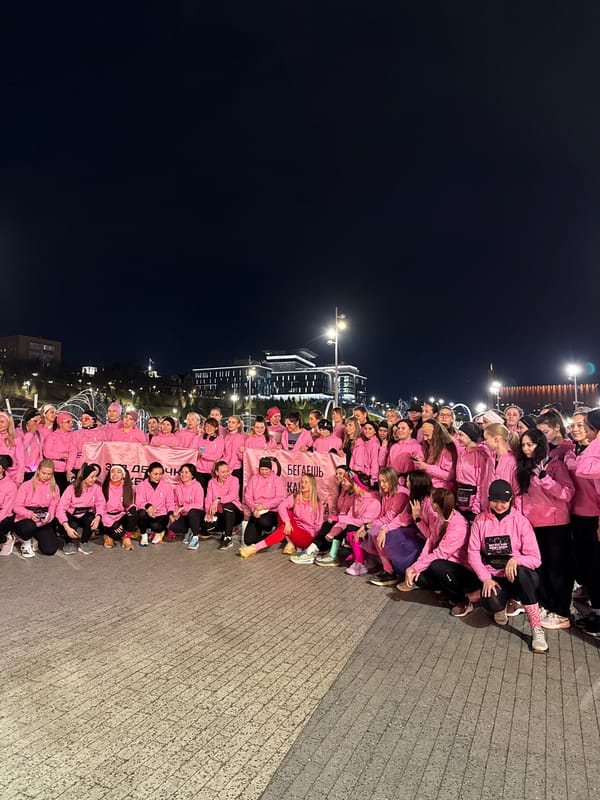 Pink-clad group poses with Cyrillic banner in Kazan