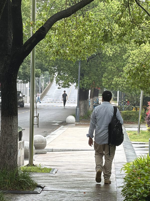 Pedestrian walks wet streets during rainy night in Jiangning