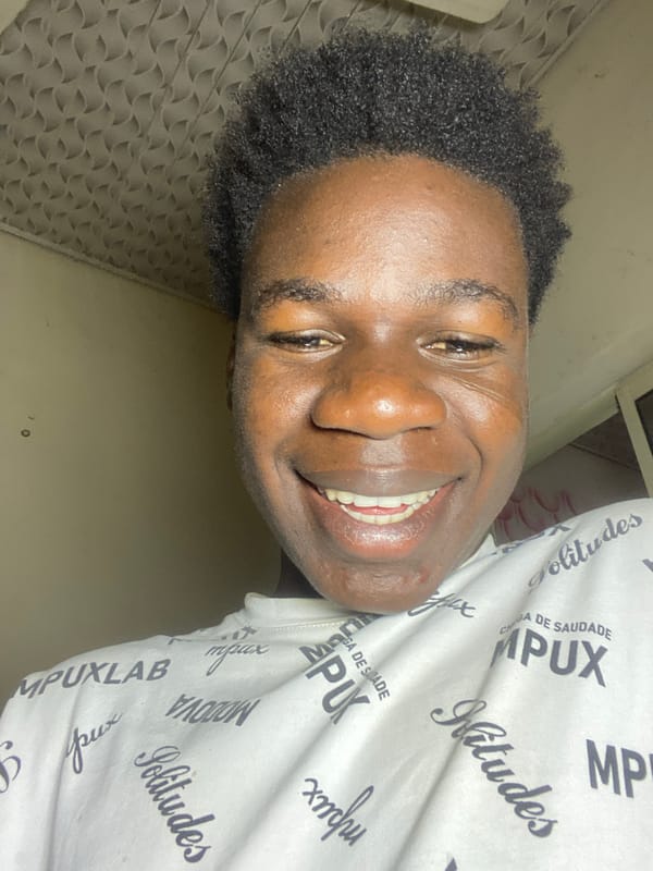Young man ironing clothes, posing in Mararaba Nigeria morning
