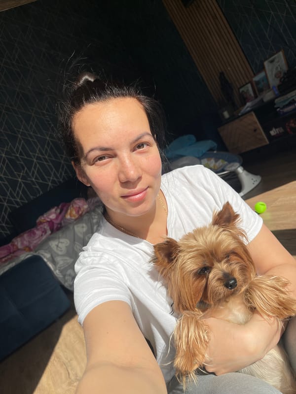 Woman poses with small dog at home