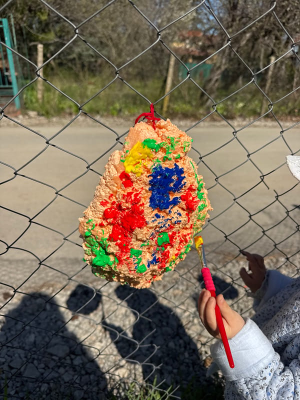 Child paints colorful artwork on fence in Sofia