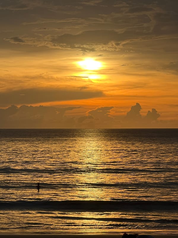 Coastal sunset documented by witnesses with aircraft overhead