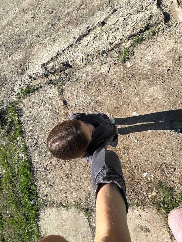Woman picks dandelions during spring morning in Perm, Russia