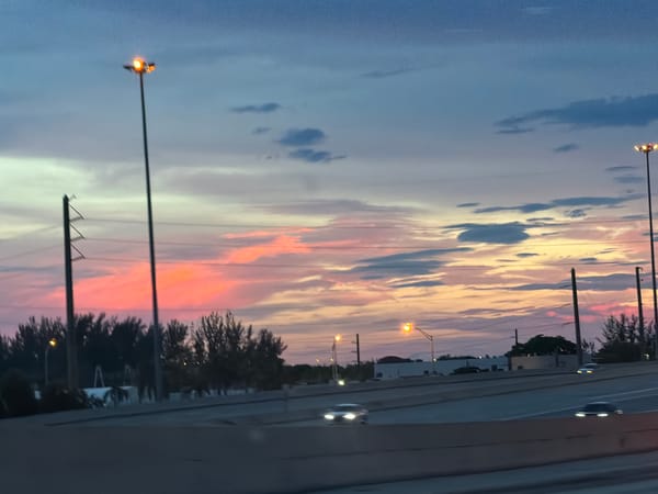 Miami highway at dusk under a colorful sunset sky