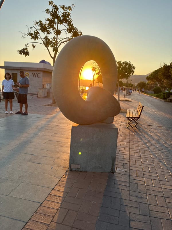 Sunset along Alanya's promenade, cats, sculptures, and beach crowds