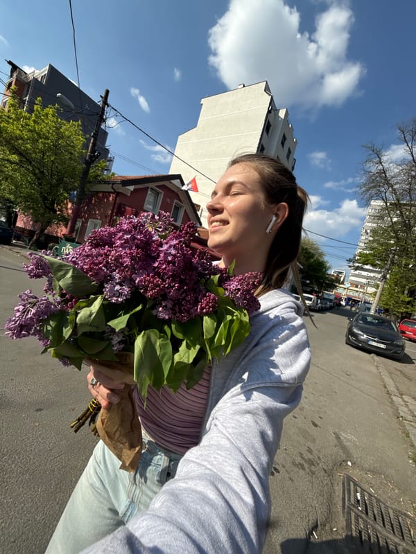 Woman poses with purple lilac bouquet on Belgrade street