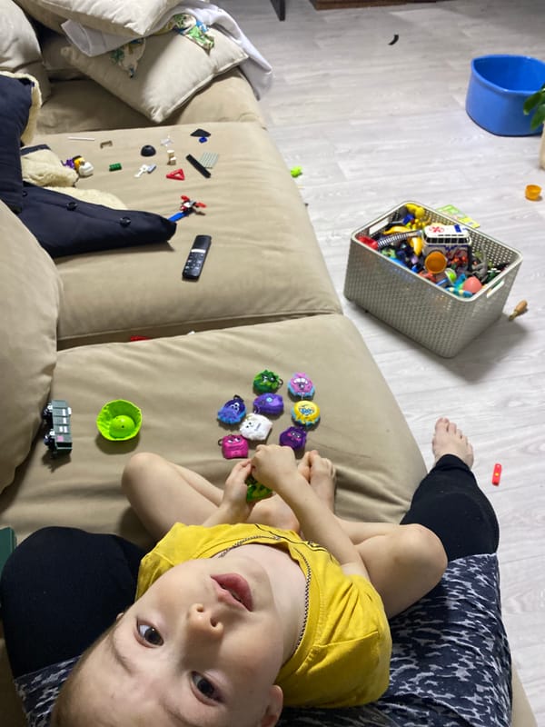 Child in yellow shirt rests on sofa in Noviy