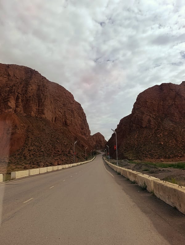 Highway threading through a red-rock gorge near Naryn, Kyrgyzstan