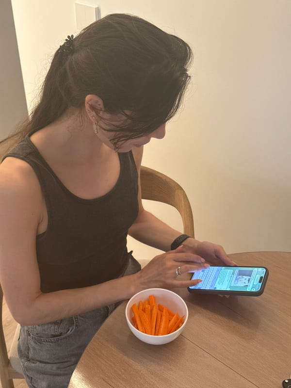 Woman uses smartphone at table with carrots in Perm