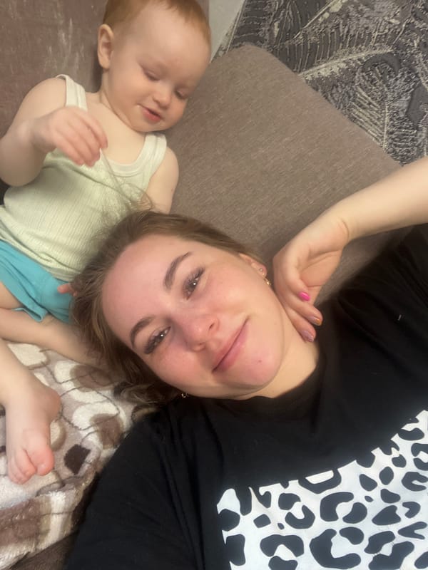 Woman and child rest on couch in Chaikovsky