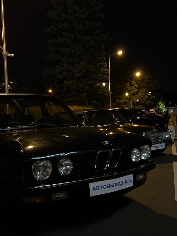 Classic and exotic cars gathered outside Moscow landmark at night