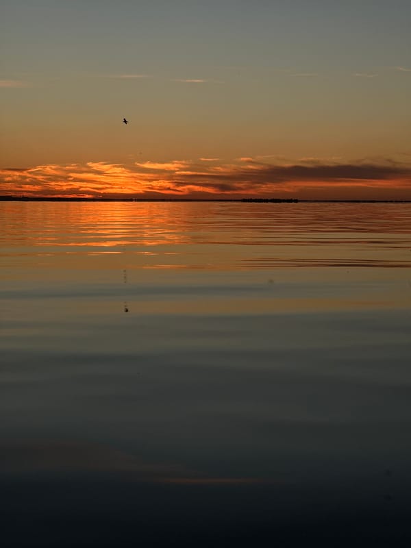 Vivid sunset reflects across calm water in Kokshetau