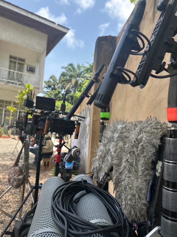 Film crew sets up equipment near parked truck in Lagos