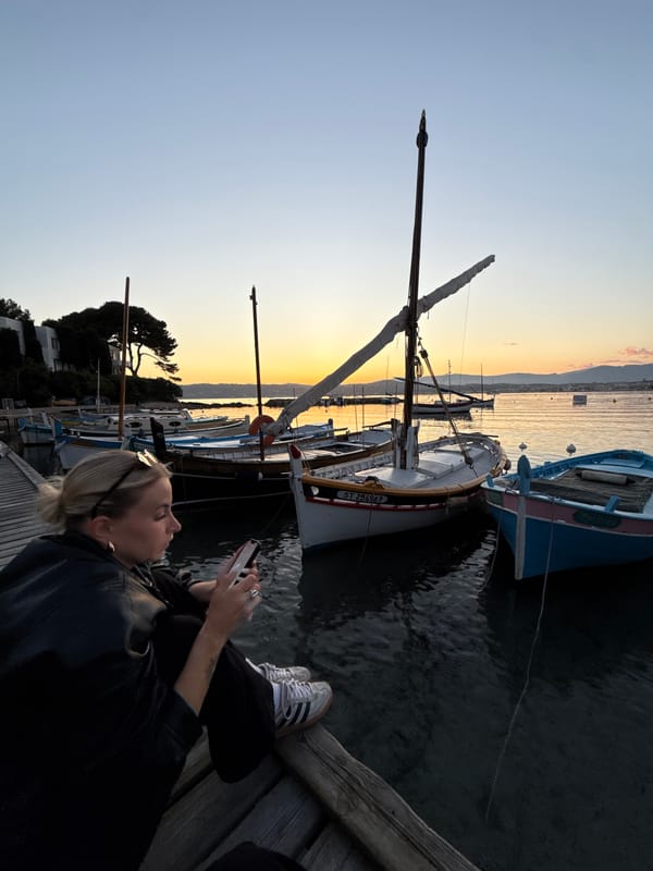 Woman uses smartphone on pier in Antibes, France