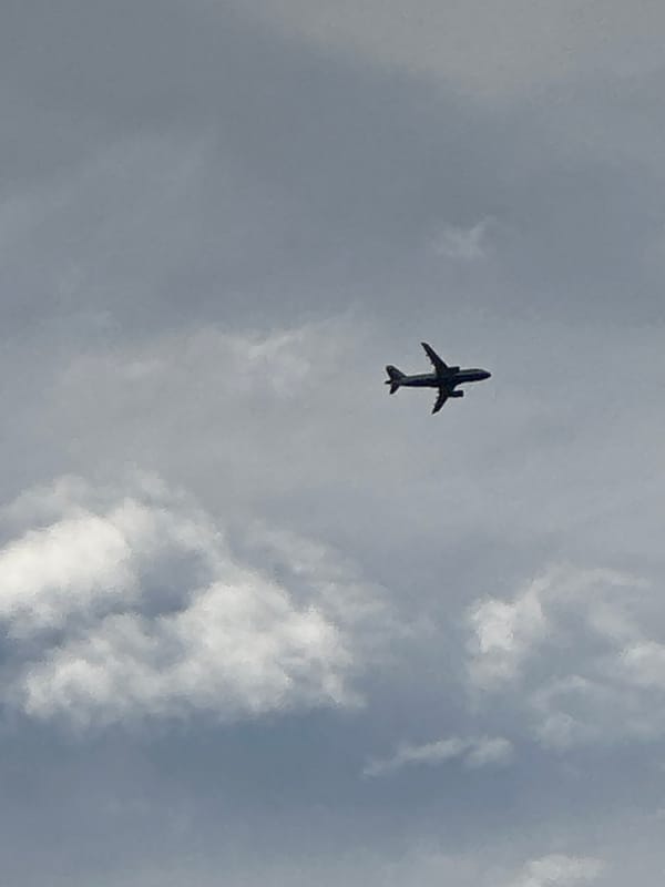 Commercial jet ascending through cloudy skies over London