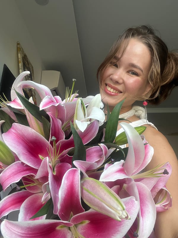 Woman poses with lily bouquet at Vietnam heritage site