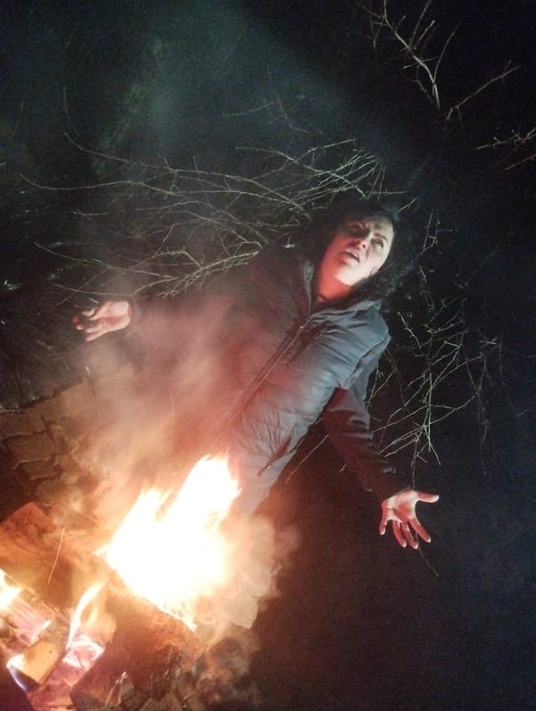 Woman photographed at nighttime bonfire gathering in Grishanki, Russia