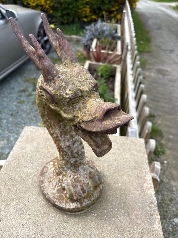 Weathered metal bird ornament spotted on concrete pillar in Minsterley