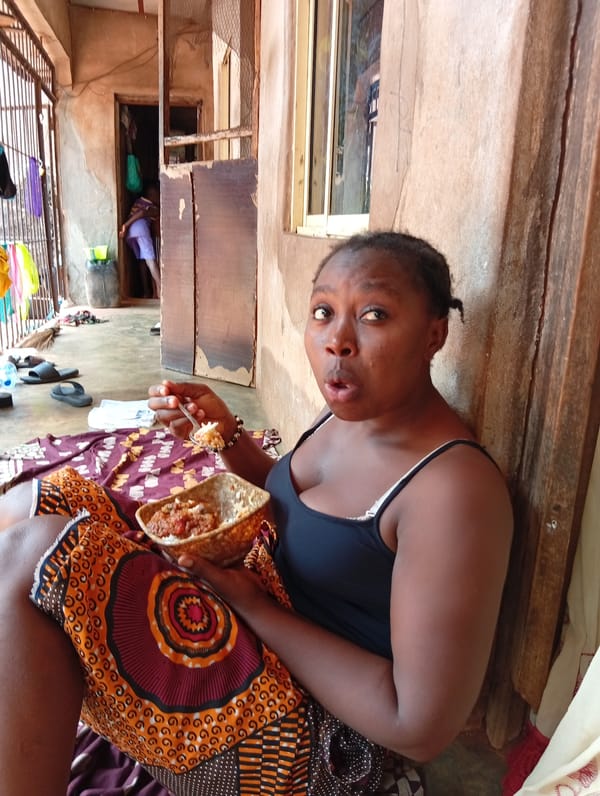 Woman shows surprised expression while eating in Ogidi, Nigeria