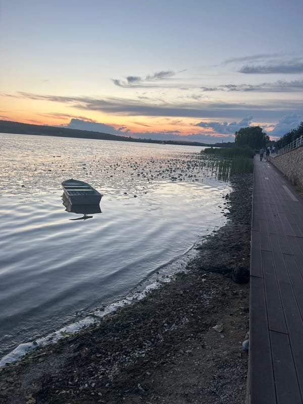 Dusk settles over Ternopil Reservoir, boat and bike at rest