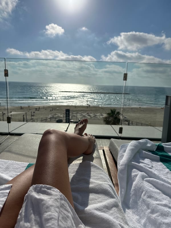 Feet up on a Tel Aviv balcony, coastline in view