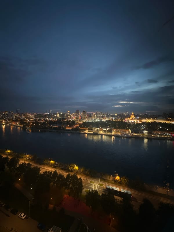 Moscow cityscape glows along the river at dusk