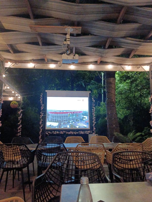 Outdoor cinema setup observed with projector and seating arrangement