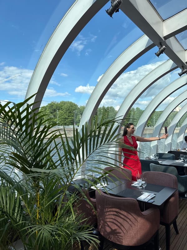 Woman takes selfie, restaurant table set in Moscow