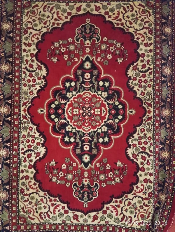 Decorative red rug with floral medallion pattern documented
