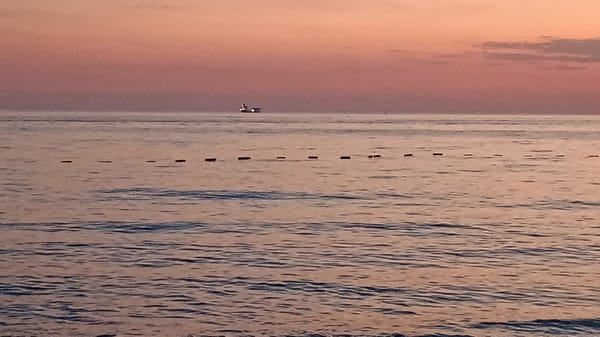 Coastal sunset gathering draws beachgoers, diners, anglers to waterfront