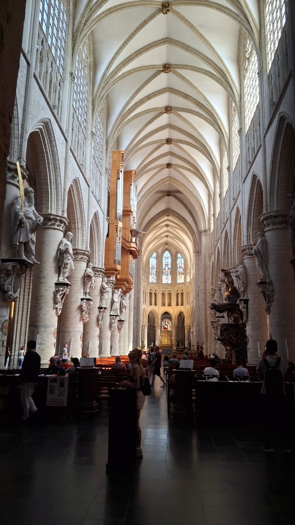Inside a grand Gothic cathedral, statues, glass, and stone.