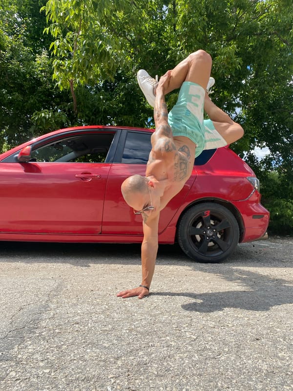 Tattooed figure poses with baseball bat near red car in Pleven